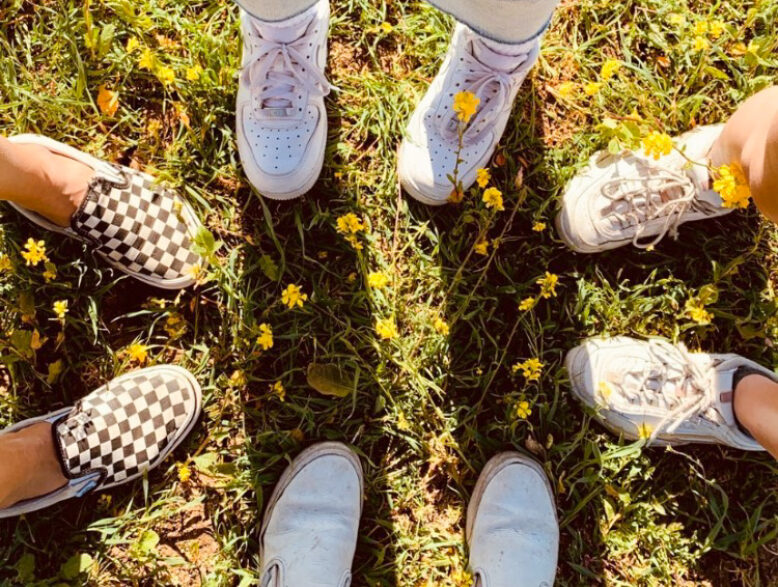 feet arranged in a circle on the grass.