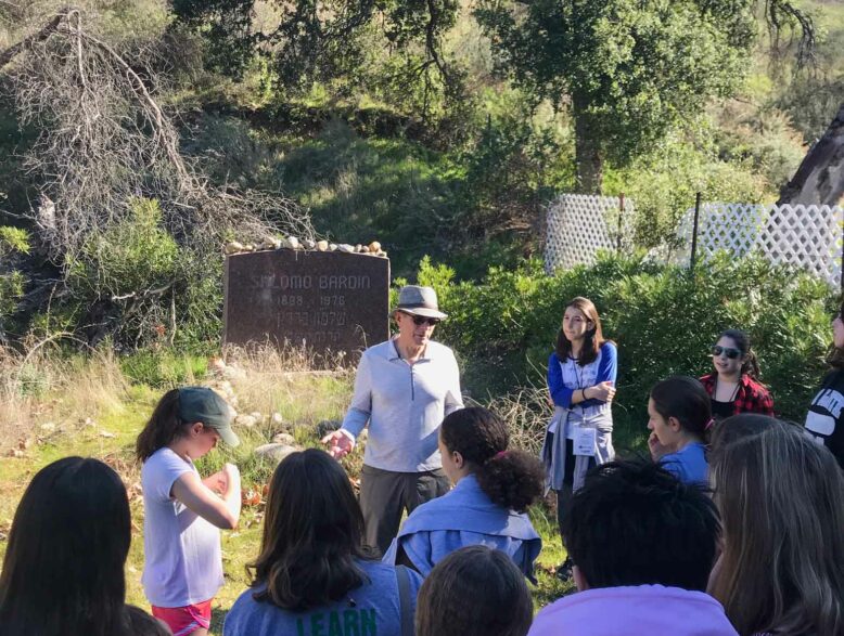 mas teaching to a group of teens outside in nature.